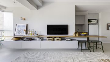 Neste apartamento de 49 m², a continuidade da bancada da sala de estar tornou-se a mesa. - Projeto: Studio Guadix | Foto: Guilherme Pucci