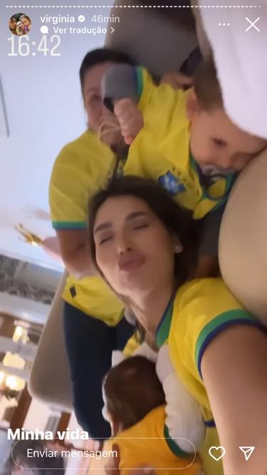 Duas mulheres e duas crianças deitadas em um sofá, com a camisa do Brasil