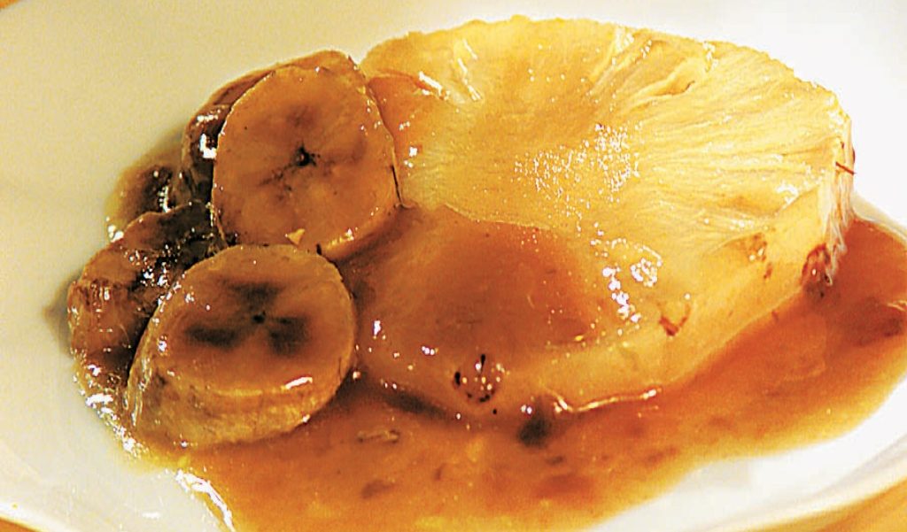 Foto de rodela de abacaxi com banana banhada em calda