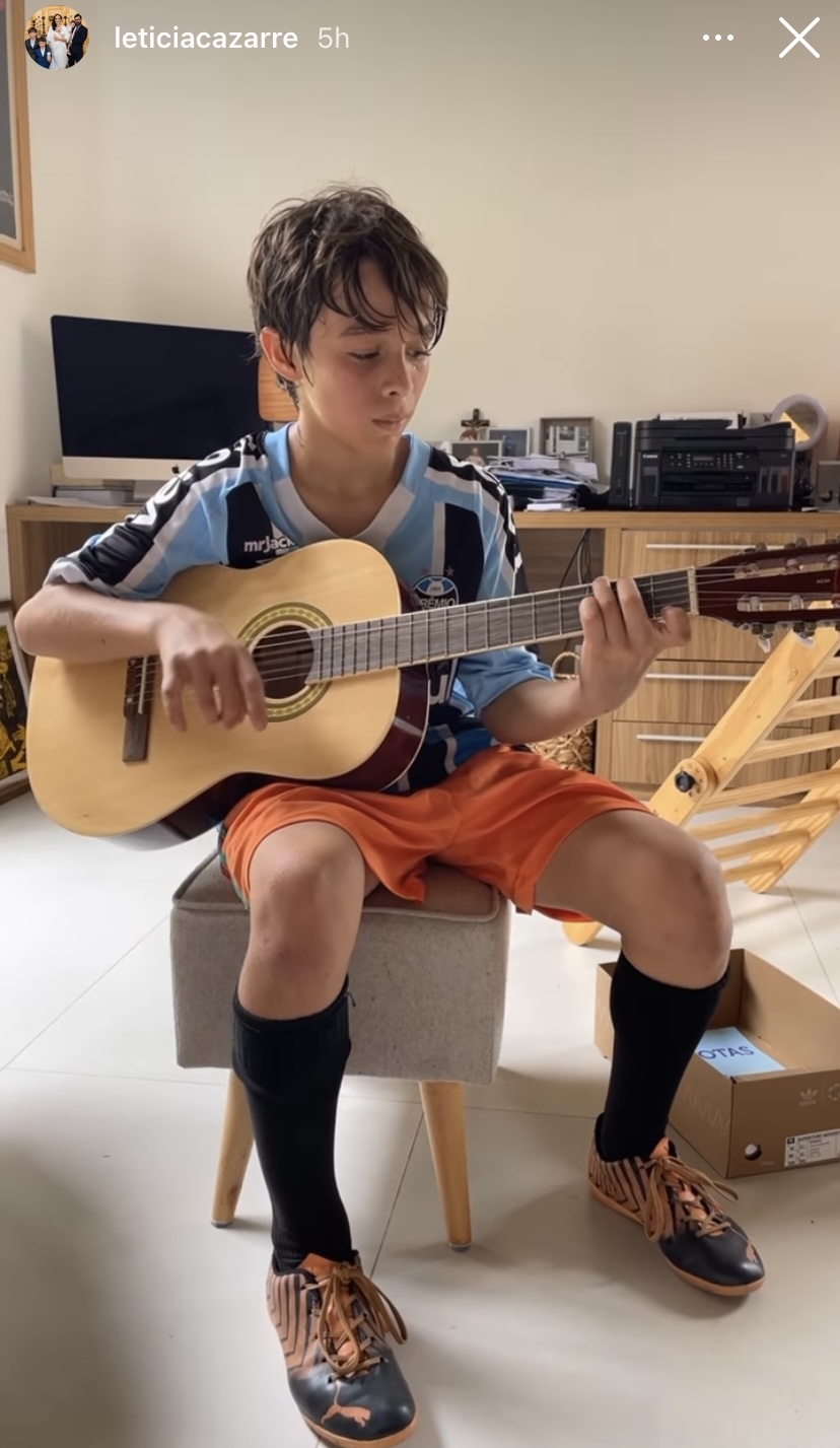 Vicente, filho de Letícia Cazarré, tocando violão