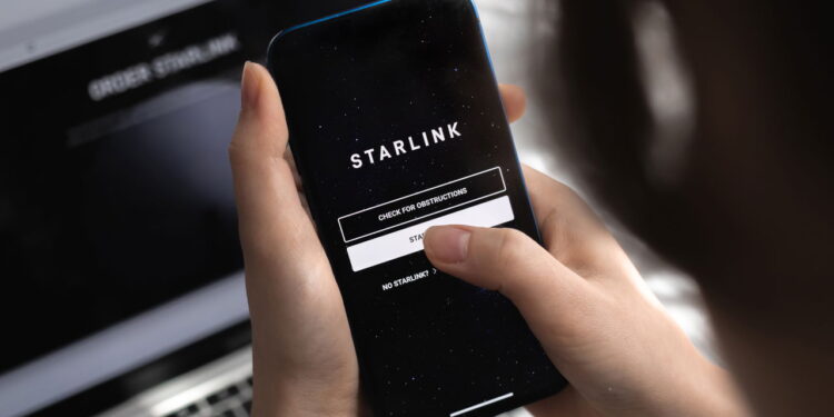 Poltava, Ukraine - March 26, 2022: Woman using Starlink app on mobile phone, Elon Musk Internet