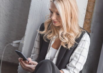 Usando celular na tomada- Créditos: depositphotos.com / AllaSerebrina