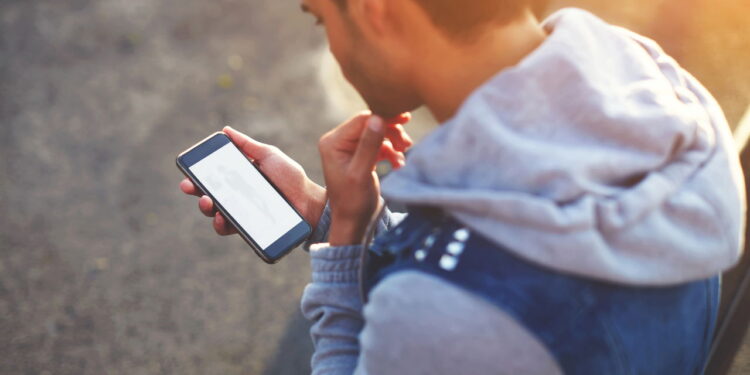 Homem usando celular - Créditos: depositphotos.com / GaudiLab