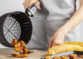 Pessoa utilizando a airfryer - Créditos: depositphotos.com / grandbrothers