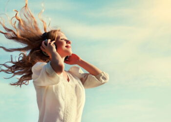 Mulher ouvindo música feliz - Créditos: depositphotos.com / evgenyataman