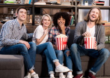 Grupo de amigos assistindo série de comédia - Créditos: depositphotos.com / VitalikRadko