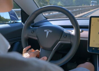 Jovem dirigindo um Tesla em uma rodovia  - Créditos: depositphotos.com / Prostock