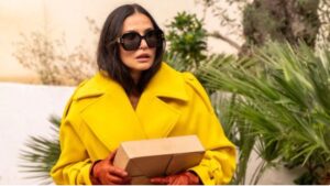 Elizabeth Sparkle vestindo sobretudo amarelo no filme A Substância | Estilo Renata Barros