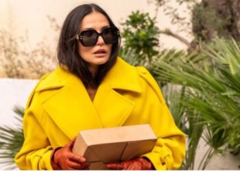 Elizabeth Sparkle vestindo sobretudo amarelo no filme A Substância | Estilo Renata Barros