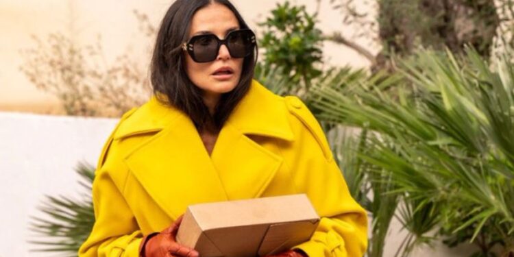 Elizabeth Sparkle vestindo sobretudo amarelo no filme A Substância | Estilo Renata Barros