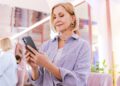 Mulher utilizando um smartphone enquanto navega na internet, ilustrando como a inteligência artificial analisa padrões de comportamento para personalizar experiências digitais.